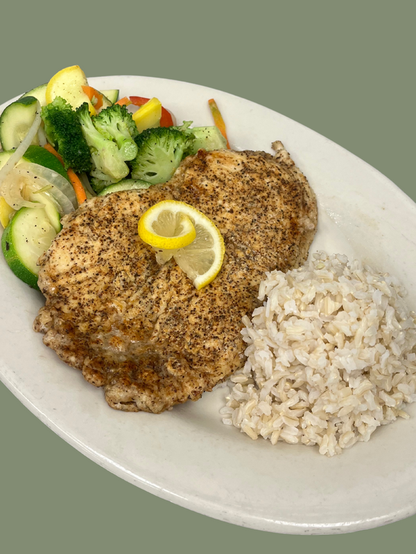Plated dish with lemon pepper seasoned grilled chicken, rice, and vegetables on a white plate.